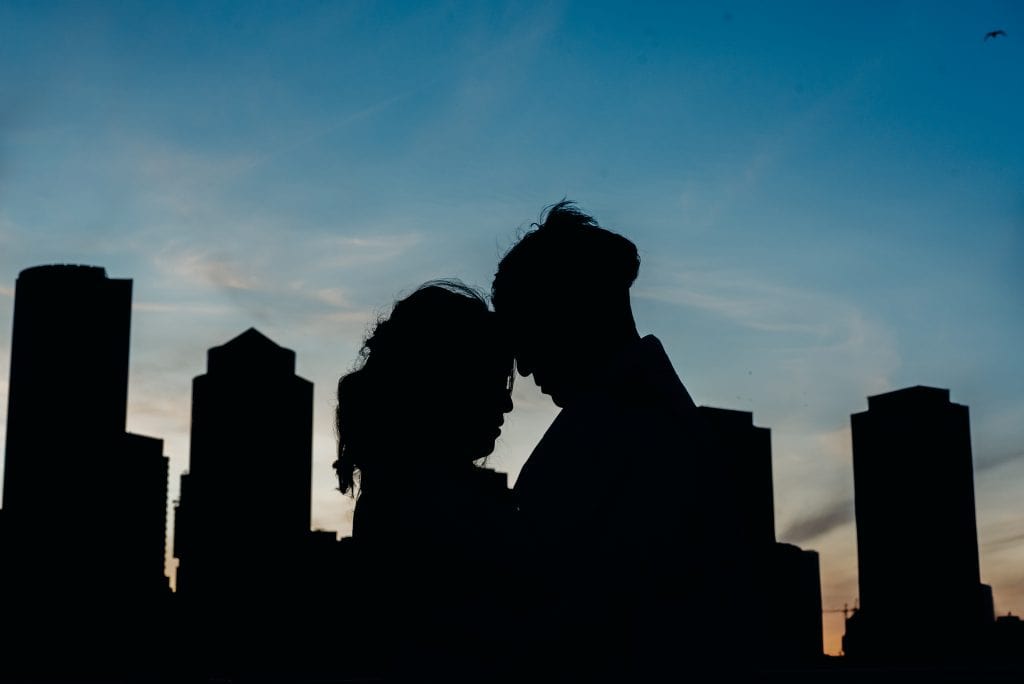 silhouette of couple and the boston city skyline during their fall boston seaport engagement session