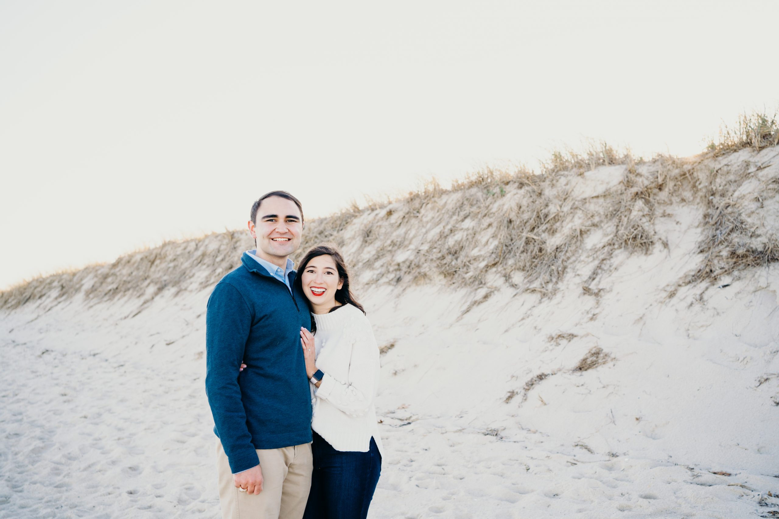 up close portrait of engaged couple in front of sand dunes during their cape cod couples session in chatham