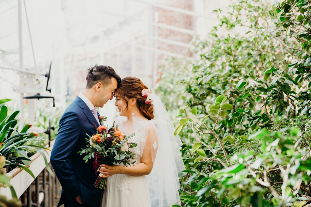 bride and groom touching foreheads in the greenhouse during their Lyman Estate wedding