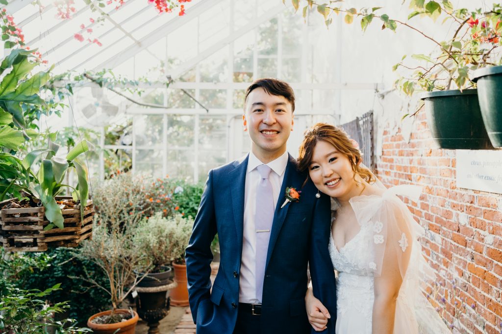 bride resting her head on the groom's shoulder in the Lyman Estate greenhouse during their intimate wedding