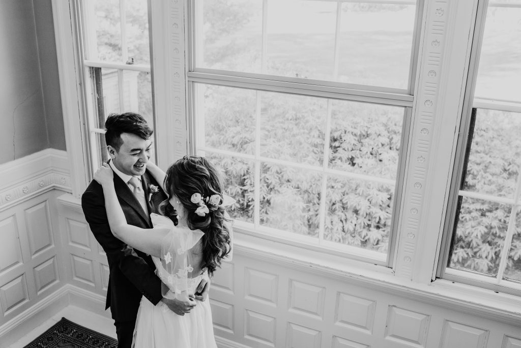 groom embracing bride after their first look on the Lyman Estate staircase