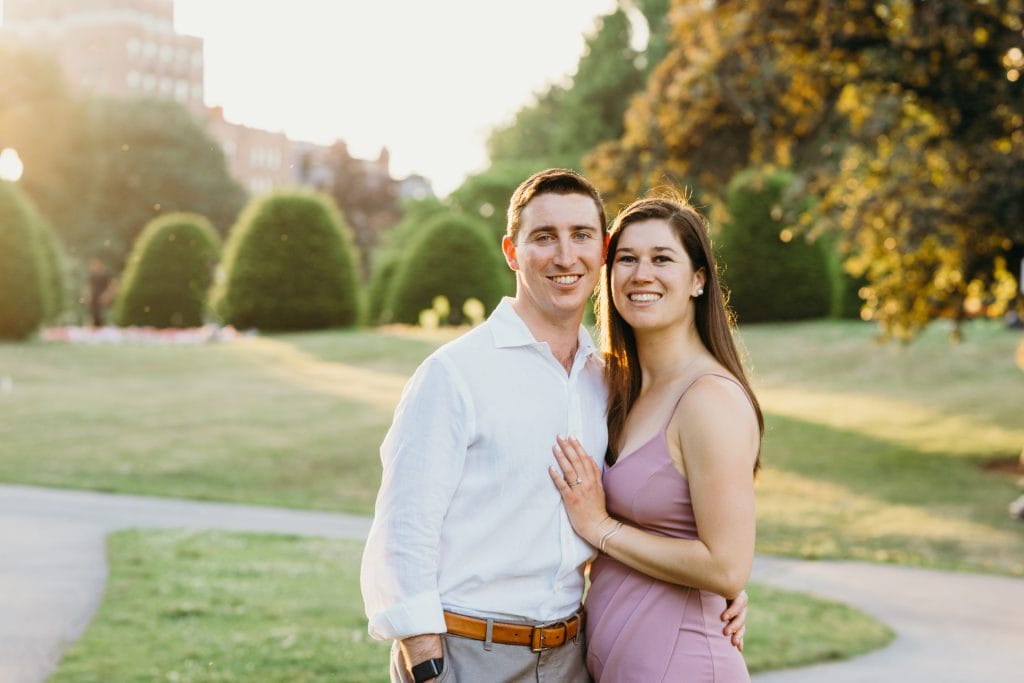 newly engaged couple smiling at camera at sunset during a Boston Public Garden proposal