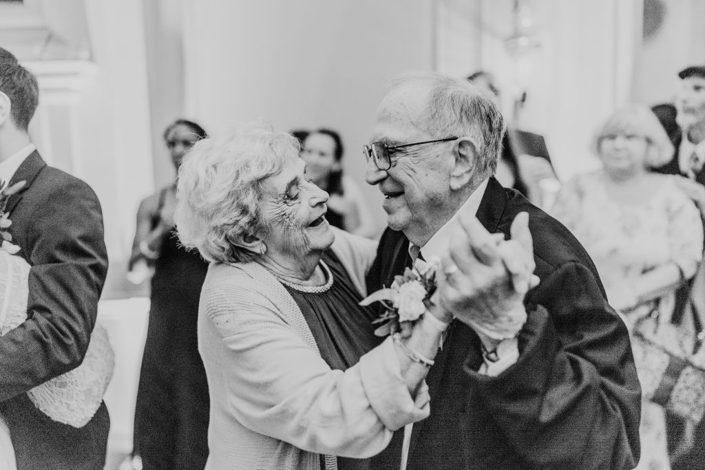 black and white photo of bride's grandparents slow dancing at their crane estate mansion wedding in Ipswich massachusetts