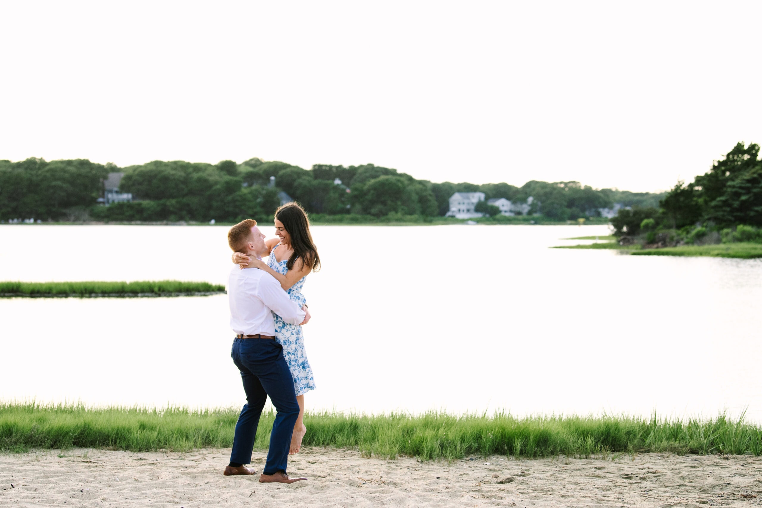 guy lifting up fiance during their cape cod surprise proposal session in massachusetts