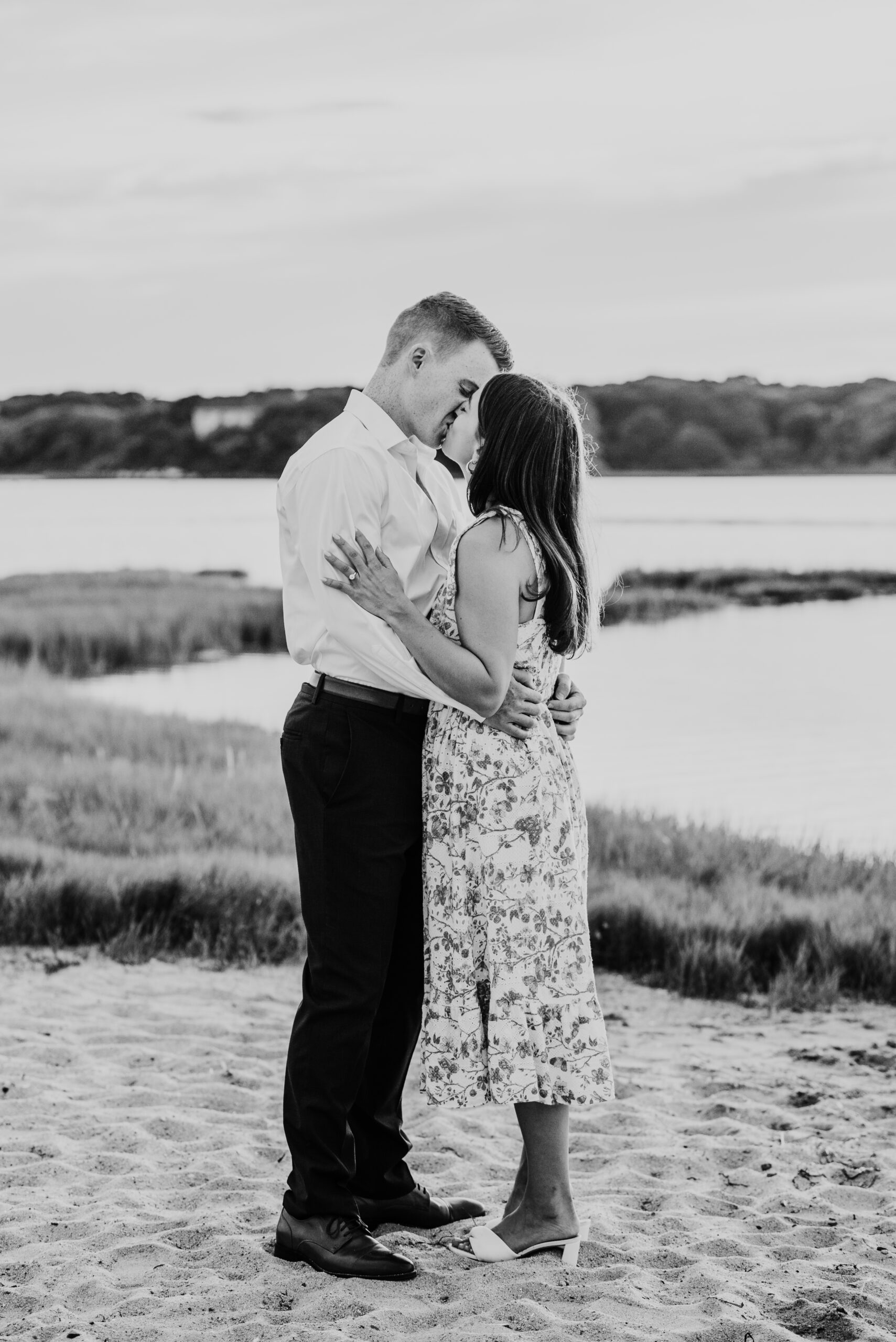 black and white photo of just engaged couple kissing each other during their falmouth cape cod sunset engagement session