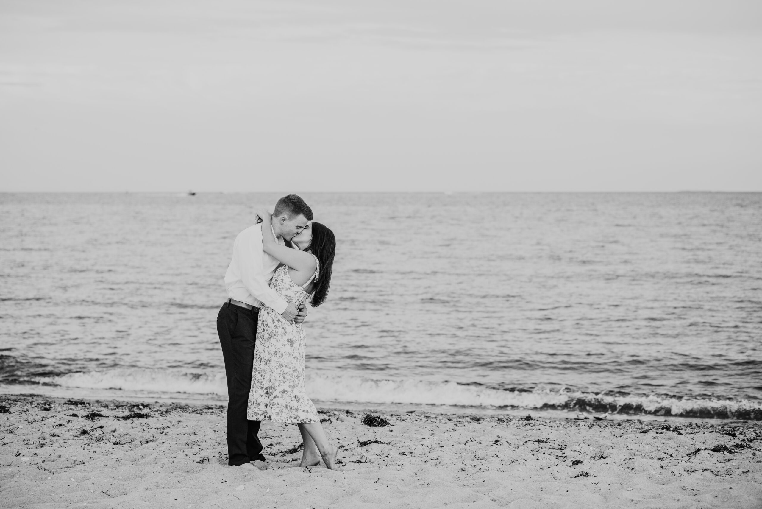 just engaged couple kissing on menahaunt beach during their falmouth cape cod surprise proposal session