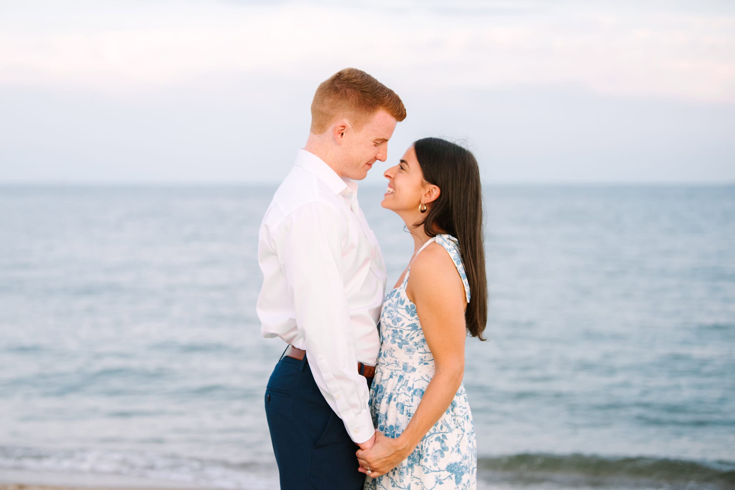 close up of newly engaged couple smiling at each other during a cape cod surprise proposal session on menahaunt beach 