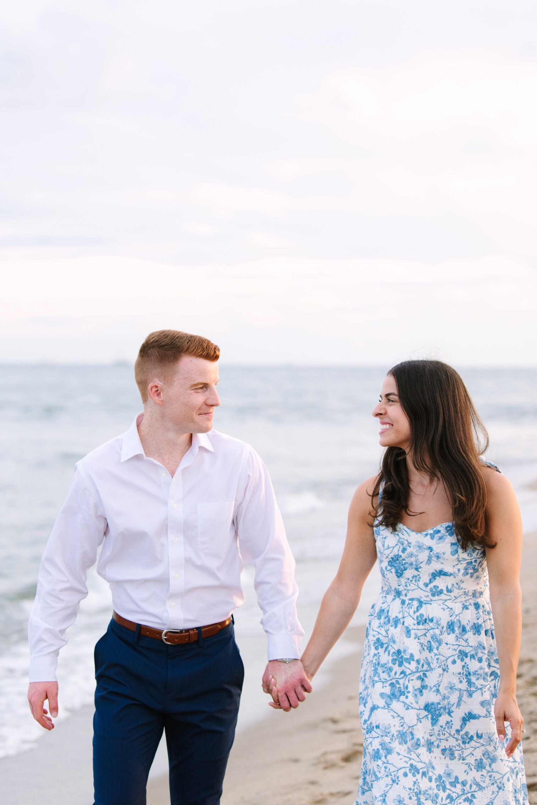 just engaged couple holding hands walking during a cape cod surprise proposal session on menahaunt beach 