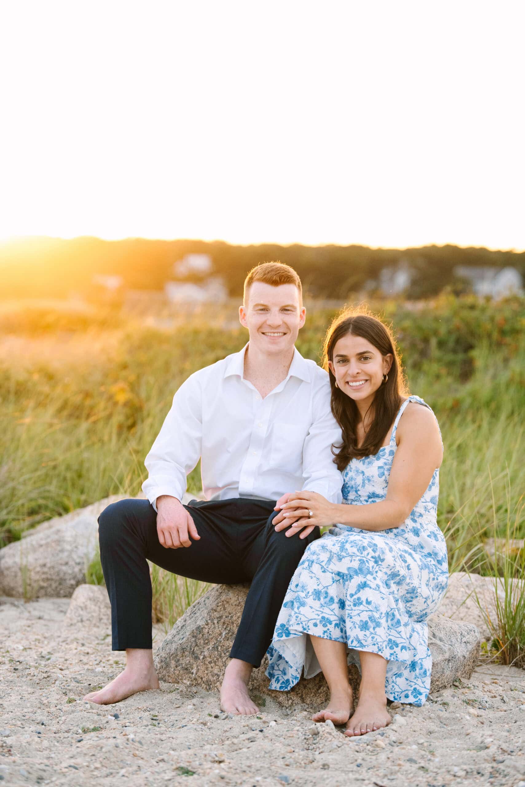 just engaged couple smiling at the camera on menahaunt beach during their falmouth cape cod surprise proposal session