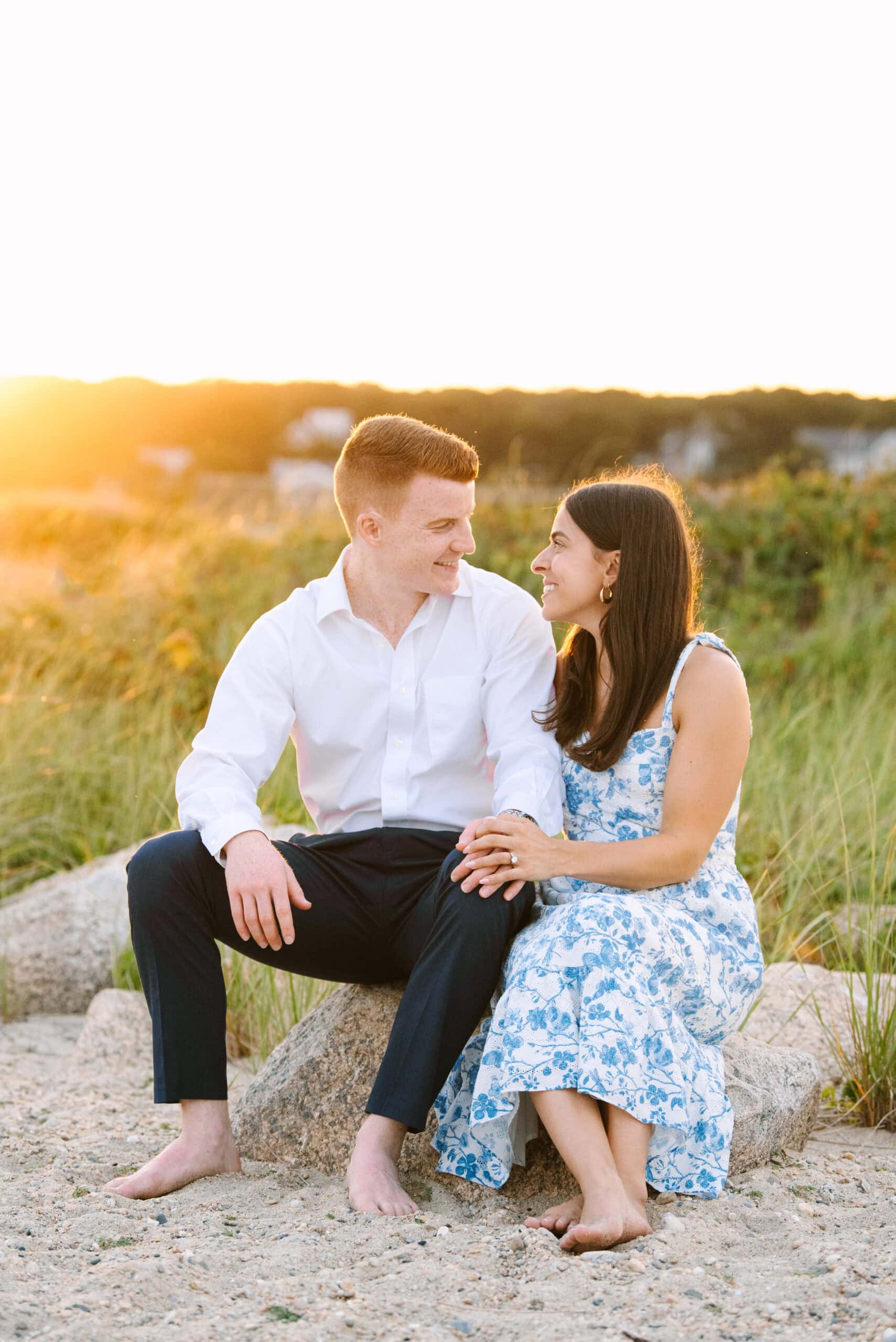 just engaged couple smiling at each other on menahaunt beach during their falmouth cape cod surprise proposal session