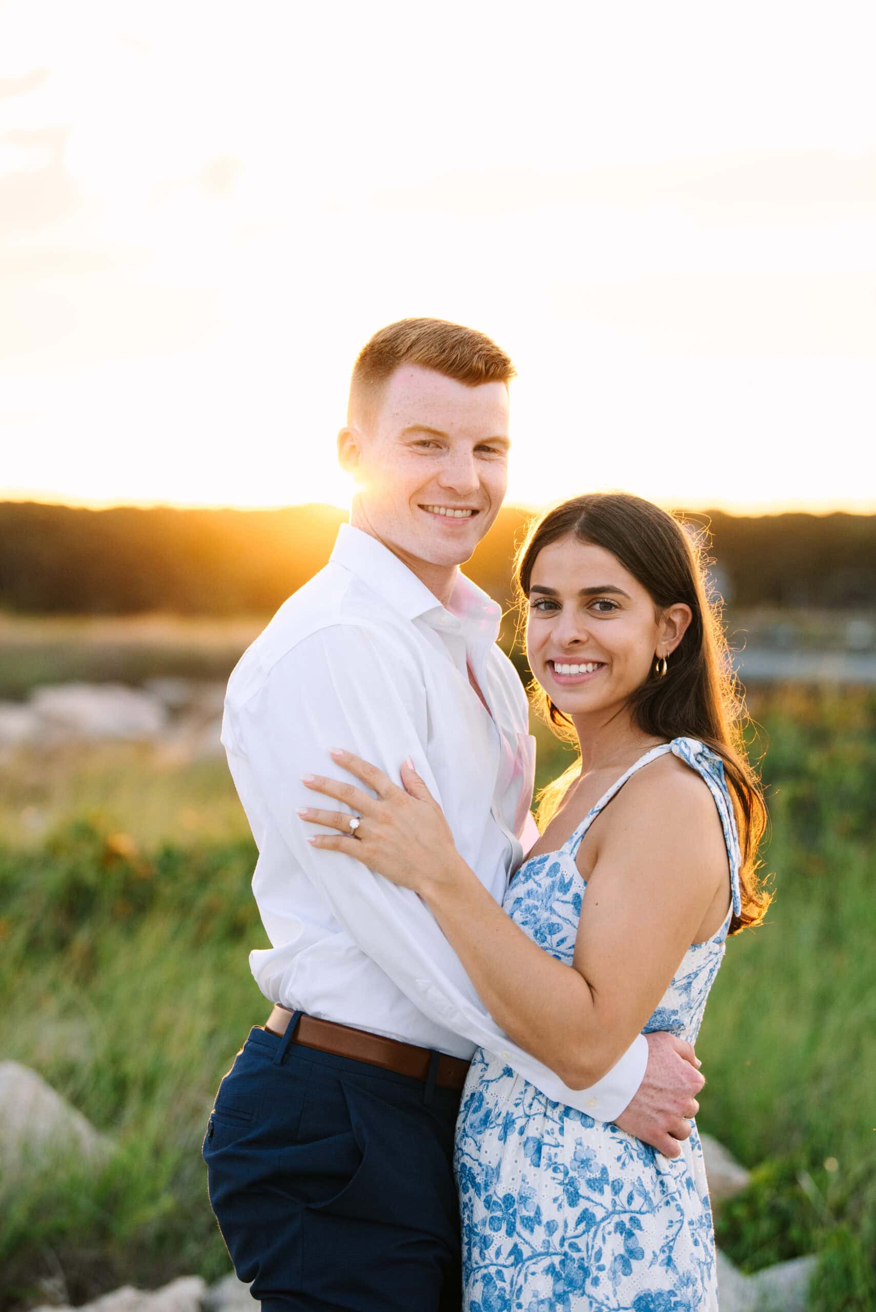 just engaged couple smiling at the camera on menahaunt beach during their falmouth cape cod proposal session