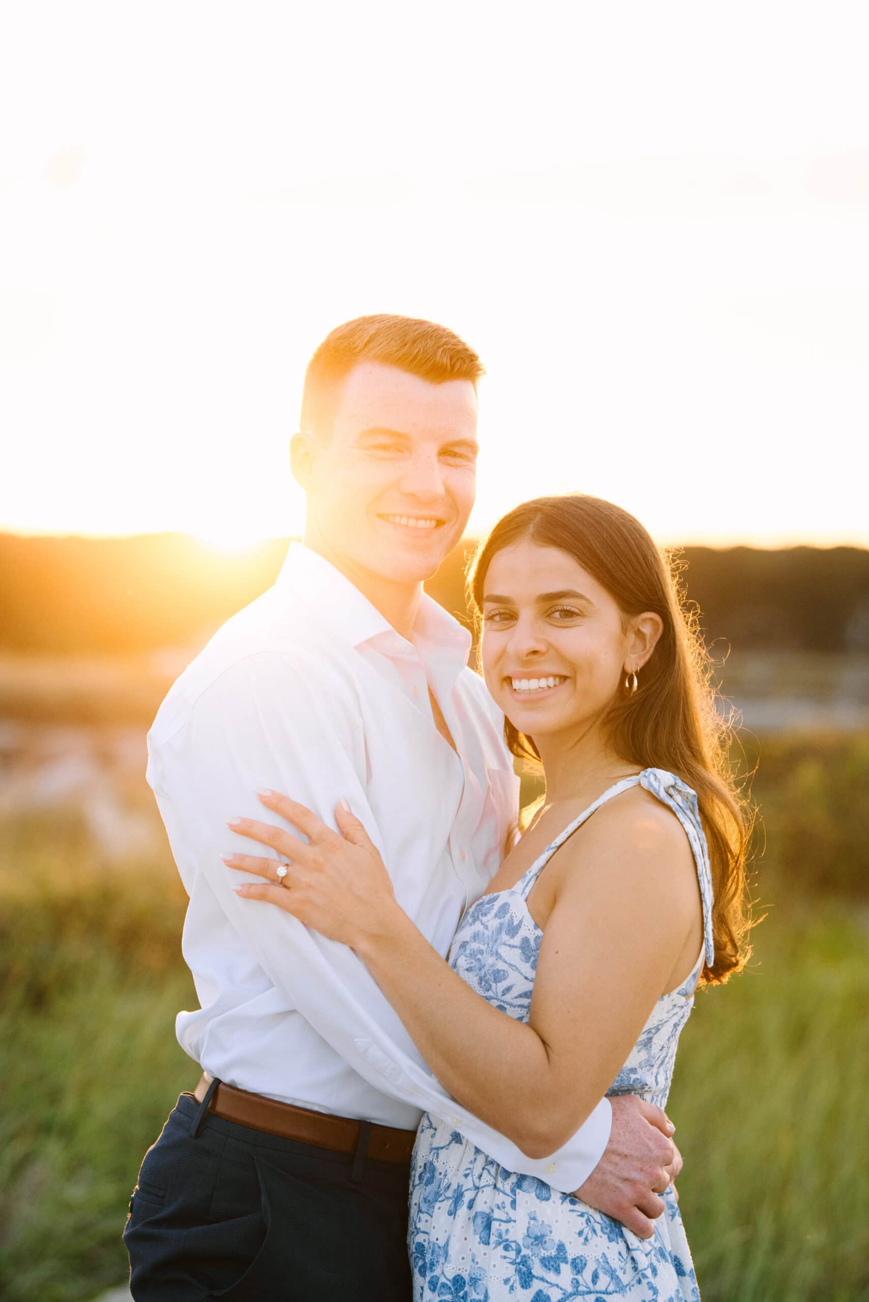 just engaged couple smiling at the camera on menahaunt beach during their falmouth cape cod proposal session