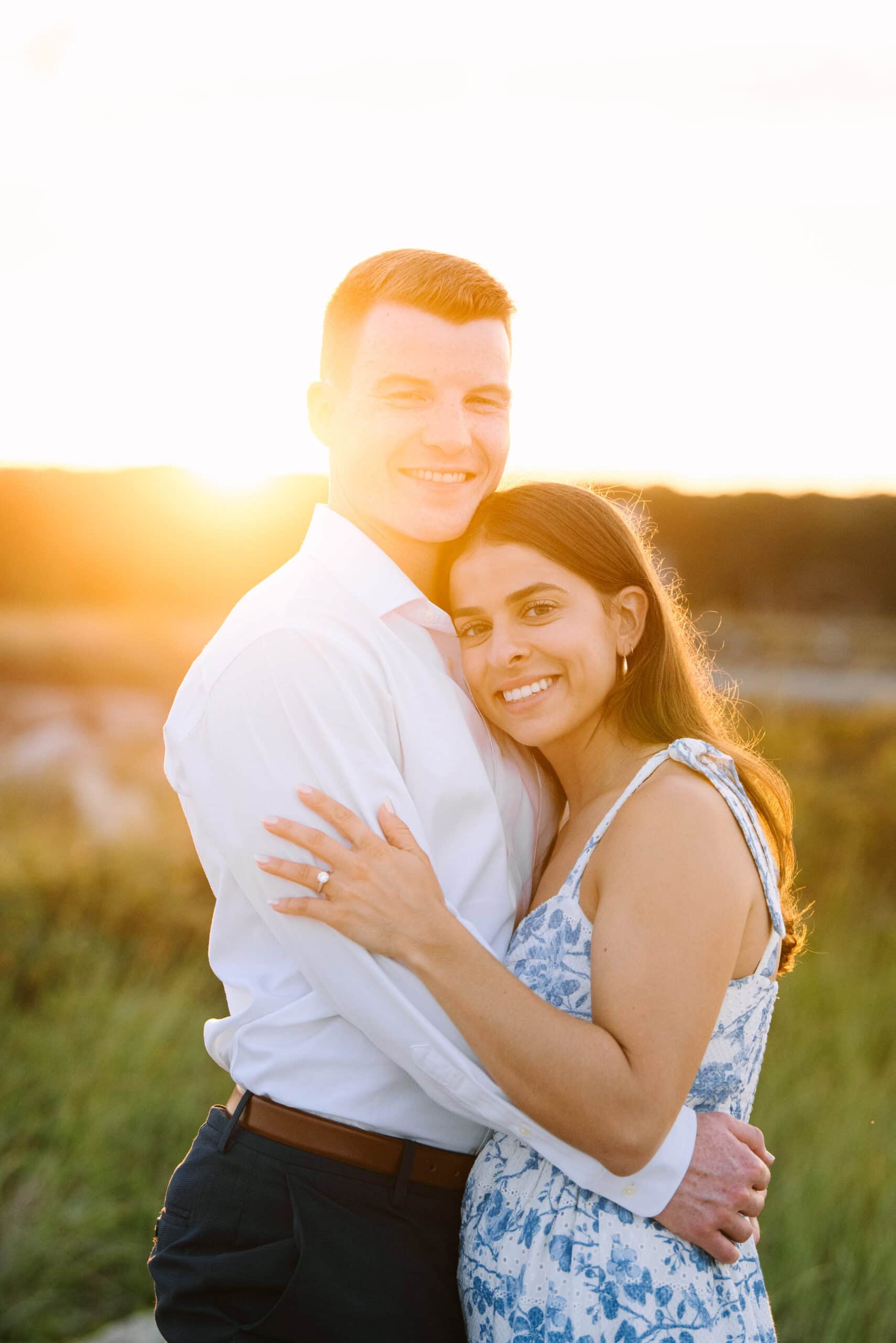 just engaged couple smiling at the camera on menahaunt beach during their falmouth cape cod proposal session