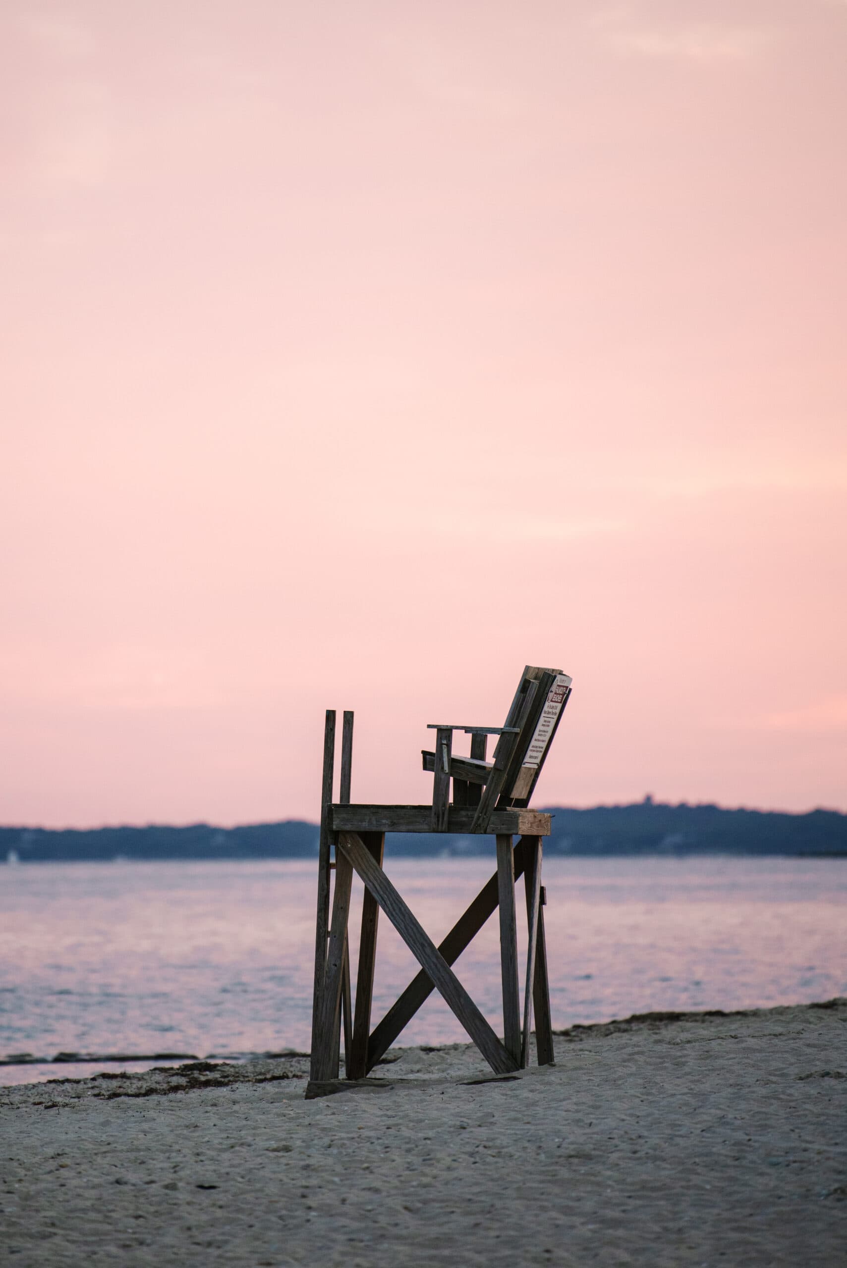 menahaunt beach lighthouse stand at sunset with pink skies in falmouth massachusetts