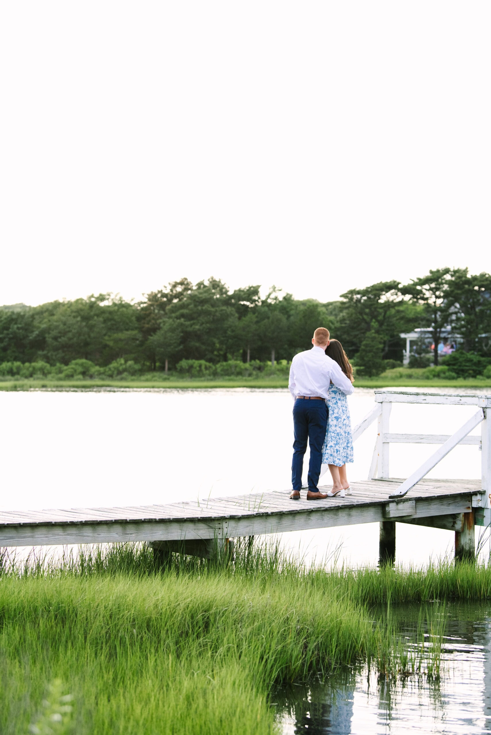 just engaged couple arm and arm looking out on the water during a surprise proposal in falmouth massachusetts