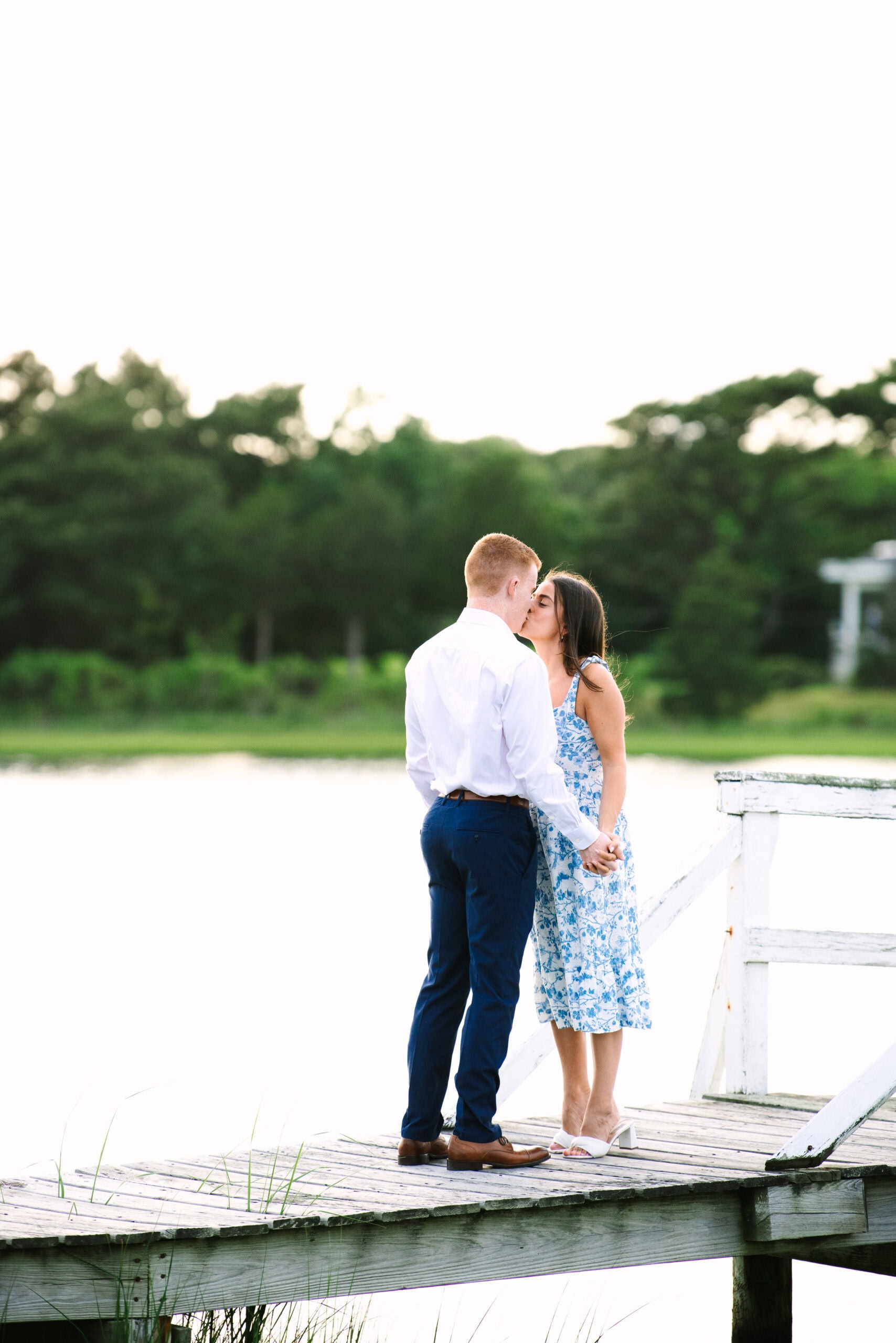 couple kissing on a bridge after just getting engaged in falmouth massachusetts