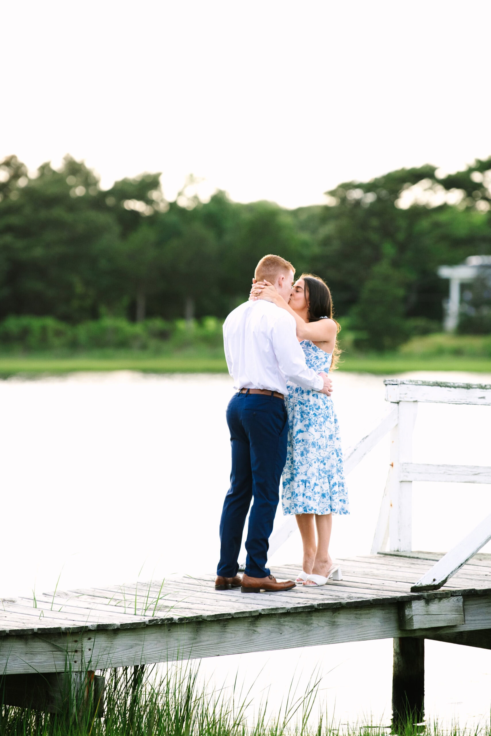 couple kissing on a bridge after just getting engaged in falmouth massachusetts