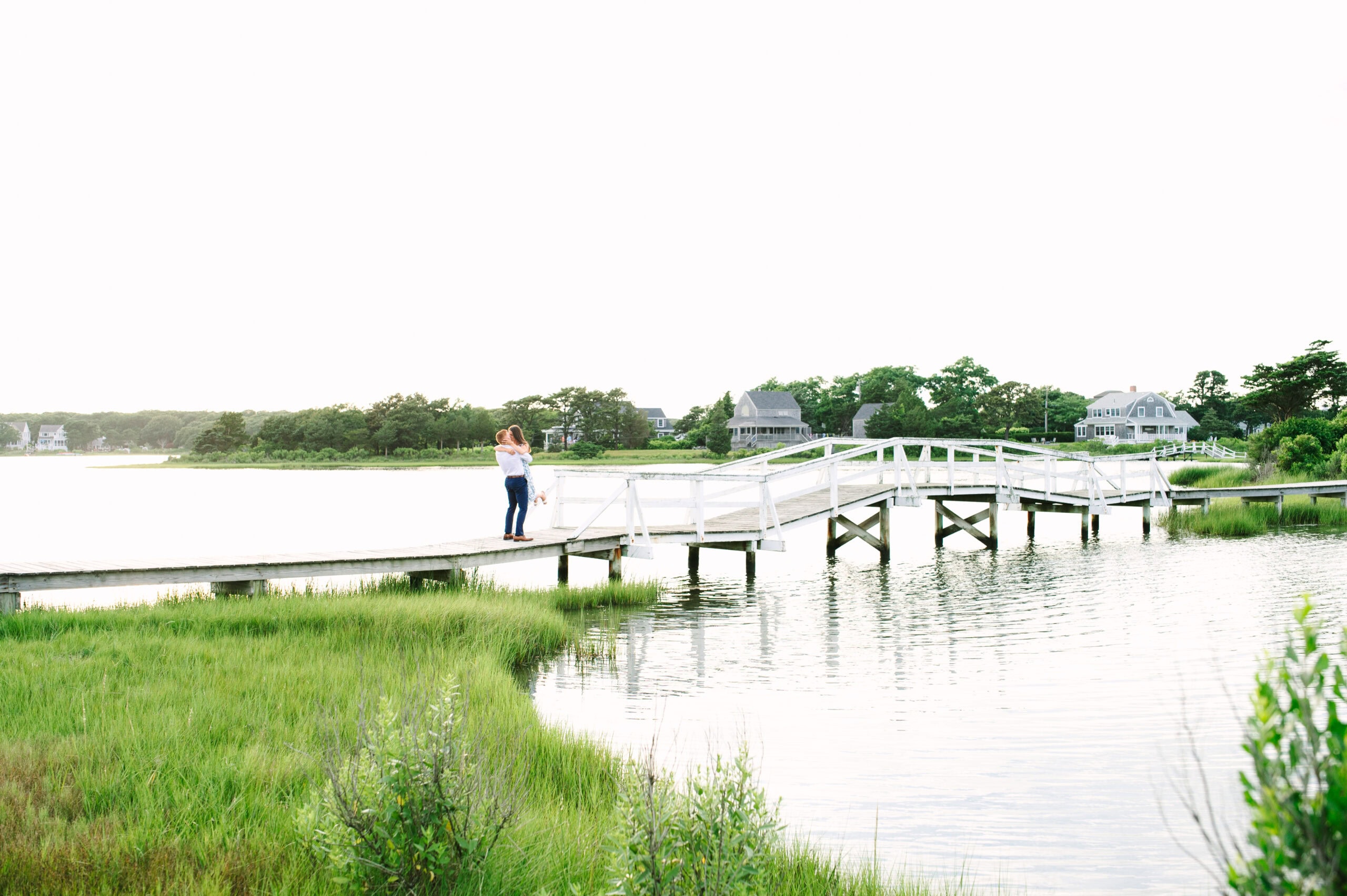 guy lifting up girlfriend after just proposing on a bridge in falmouth during a cape cod surprise proposal