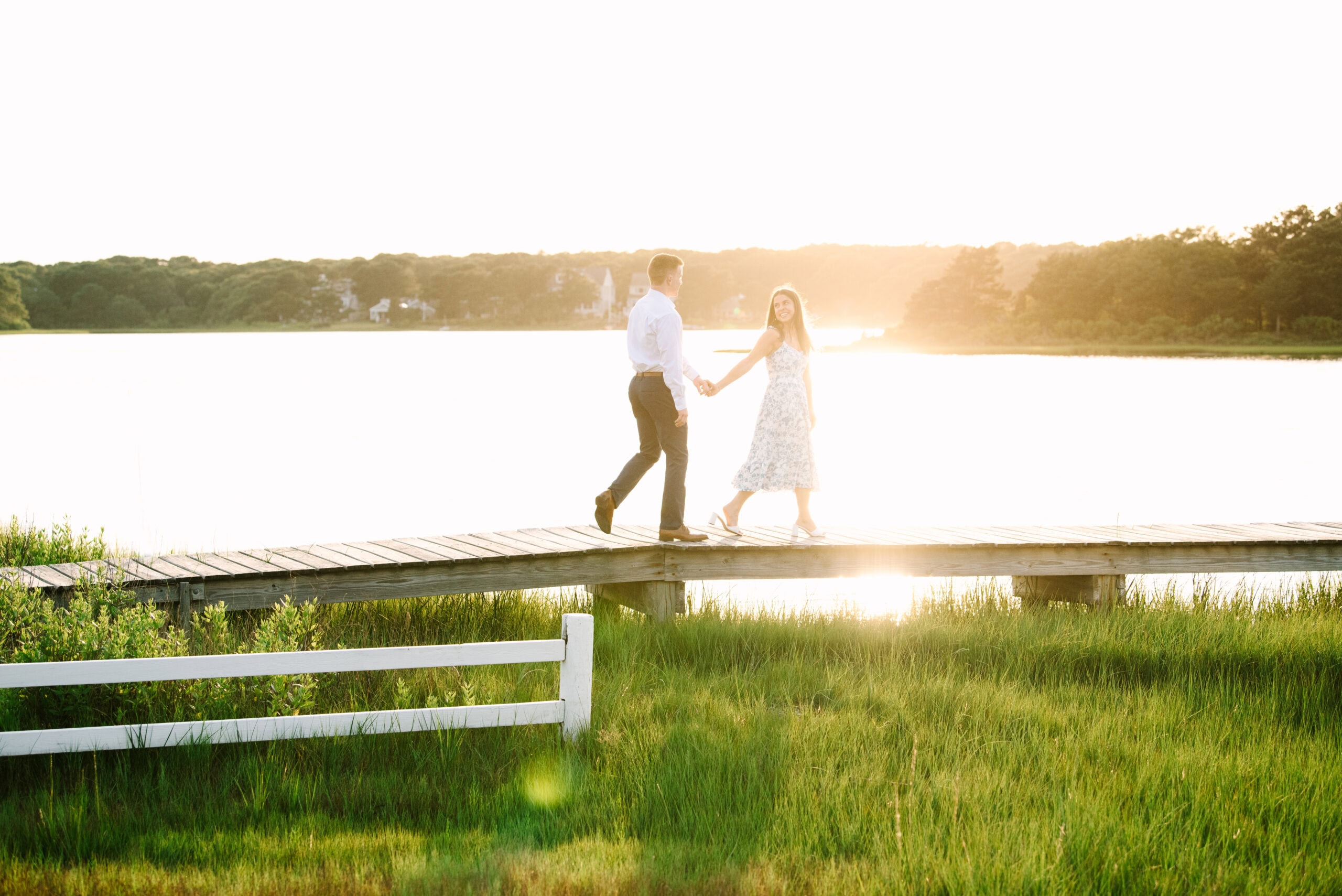 just engaged couple holding hands walking on a bridge during their falmouth cape cod engagement session