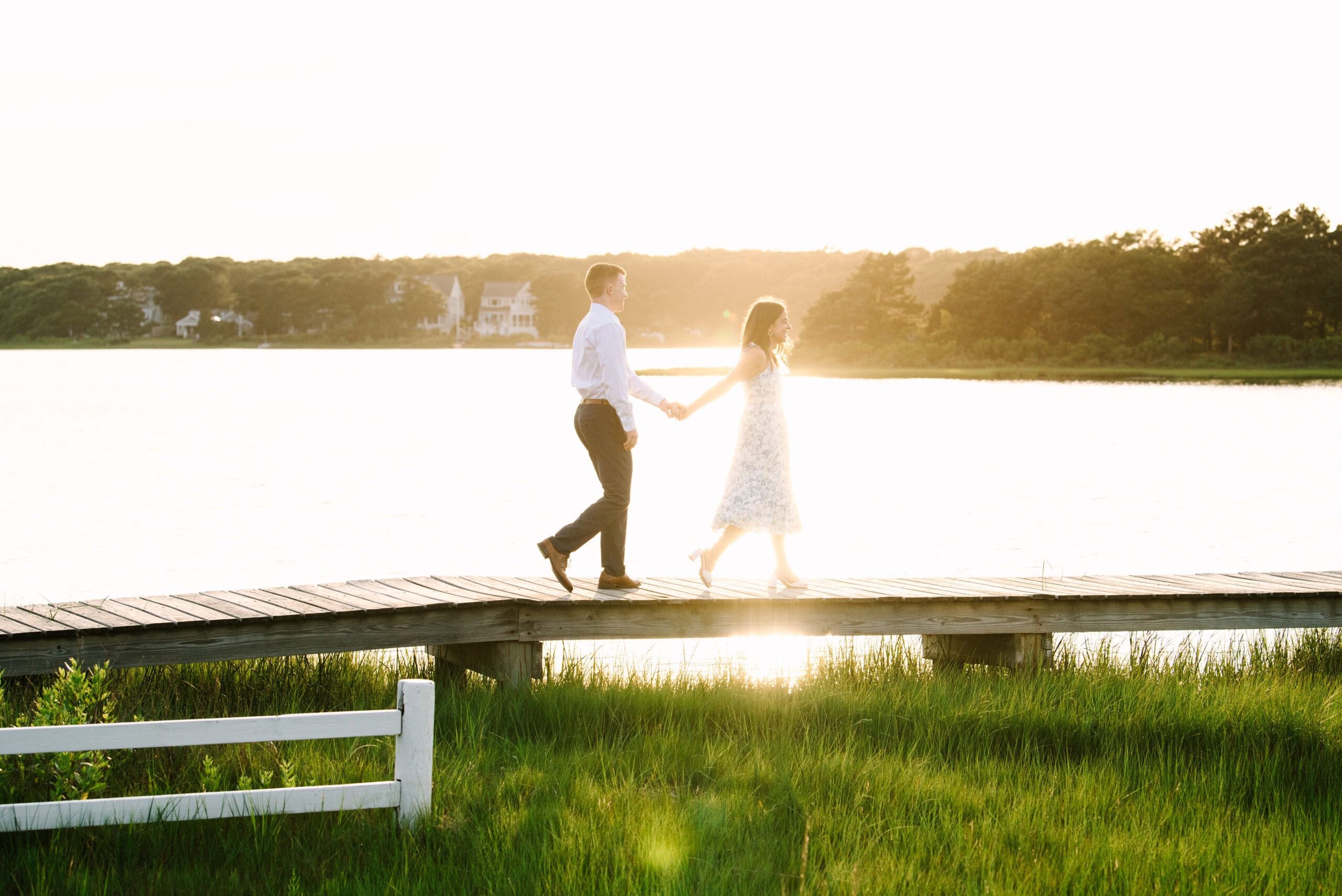 just engaged couple holding hands walking on a bridge during their falmouth cape cod engagement session