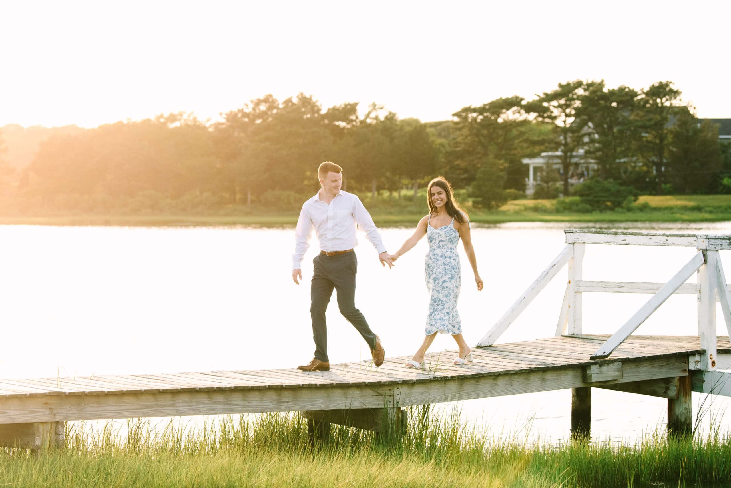 just engaged couple holding hands walking on a bridge during their falmouth cape cod engagement session