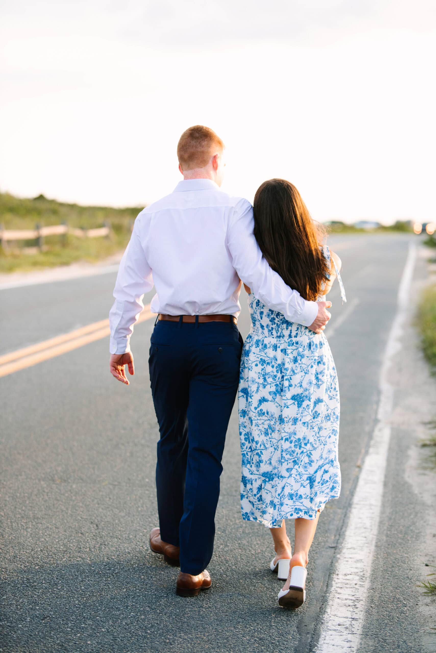 just engaged couple walking the road during their cape cod sunset engagement session