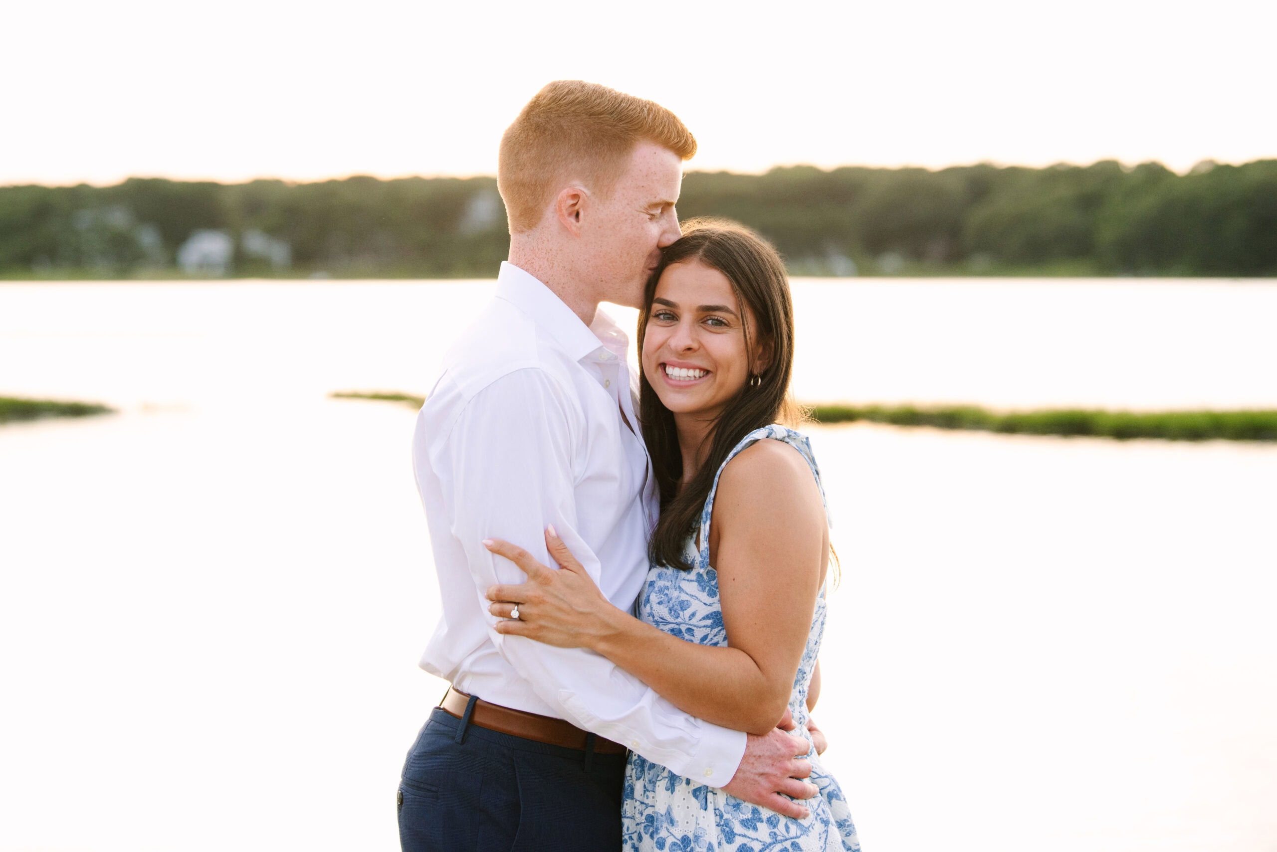 guy kissing fiance on the forehead during their sunset falmouth cape cod engagement session