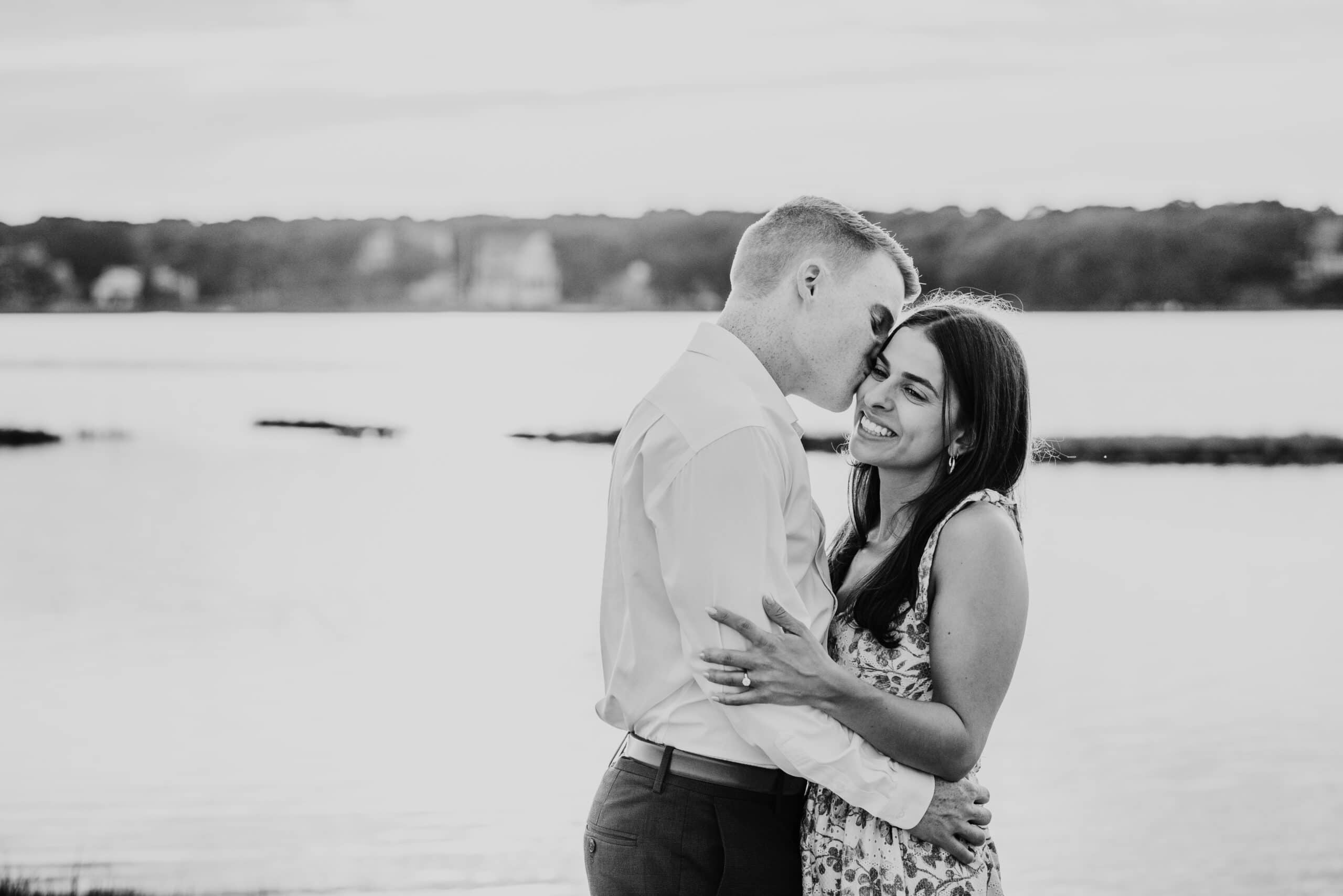 guy kissing fiance on the cheek during their sunset falmouth cape cod engagement session