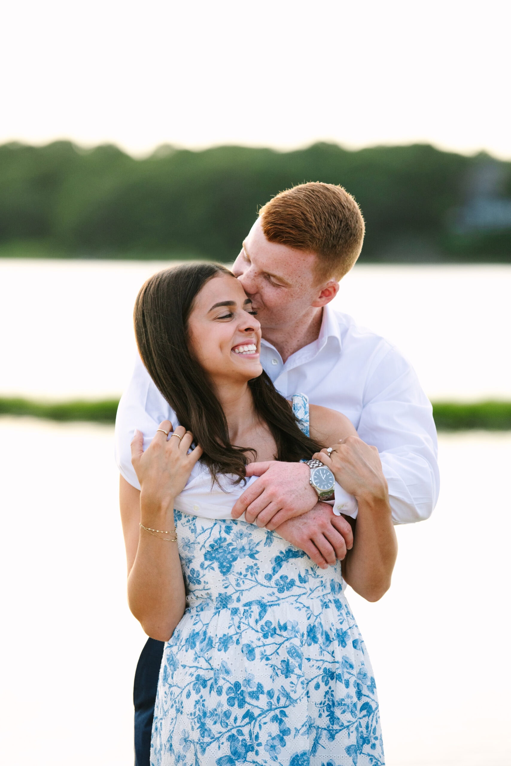 guy kissing fiance on the cheek during their sunset falmouth cape cod engagement session