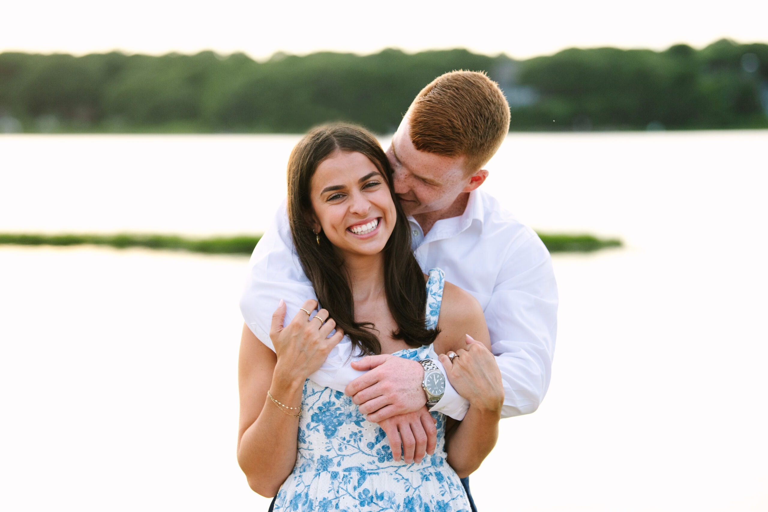 guy kissing fiance on the cheek during their sunset falmouth cape cod engagement session