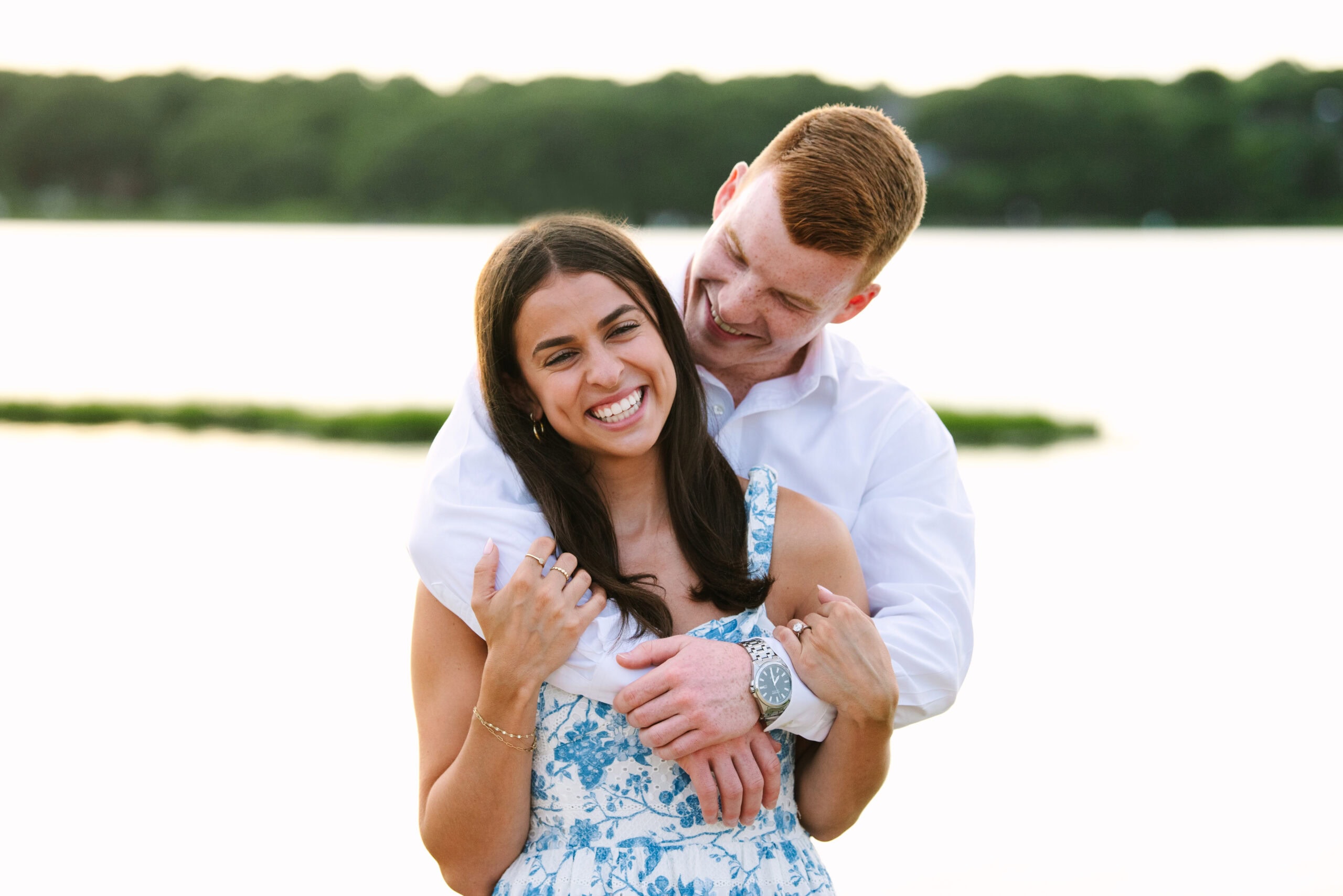 just engaged couple arm in arm laughing during their cape cod surprise proposal session captured by Meghan Lynch