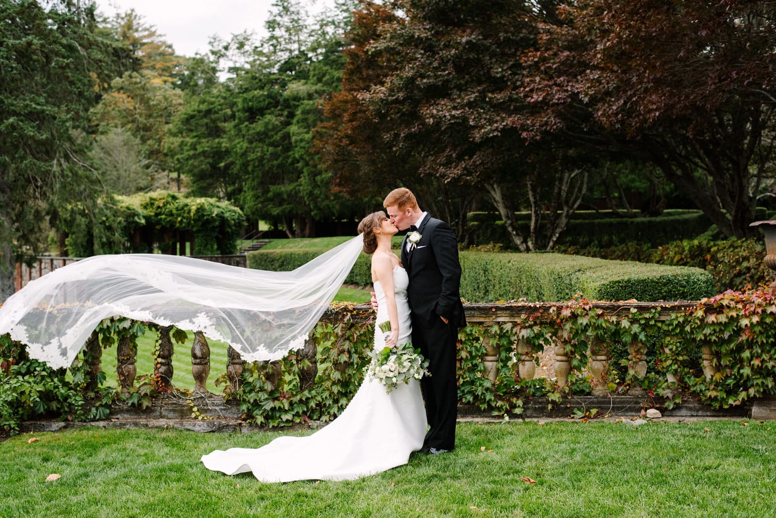 bride and groom portrait at turner hill with veil blowing in the wind by massachusetts wedding photographer Meghan Lynch