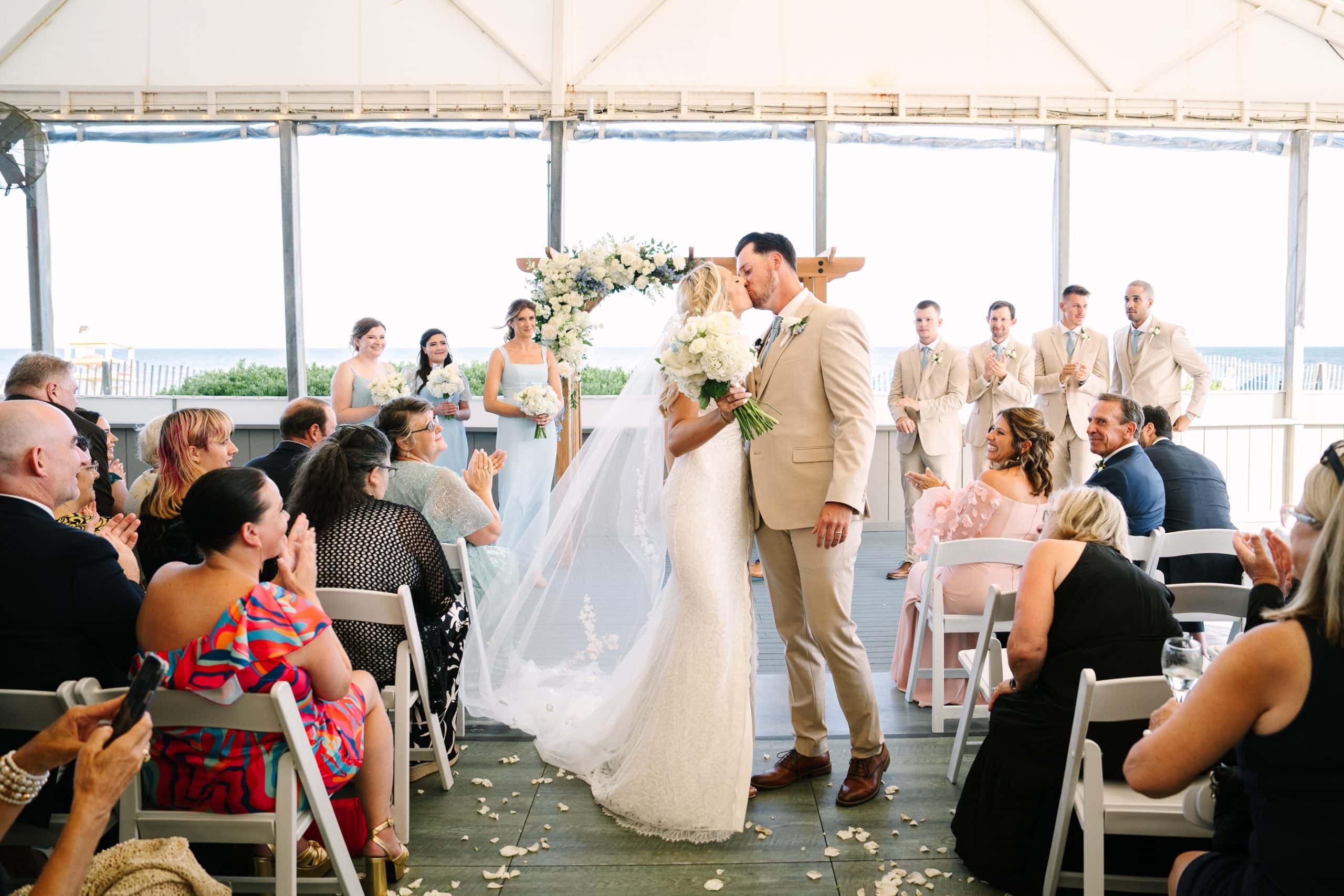 bride and groom ceremony aisle kiss at their Popponesset Inn tent celebration in Mashpee Massachusetts