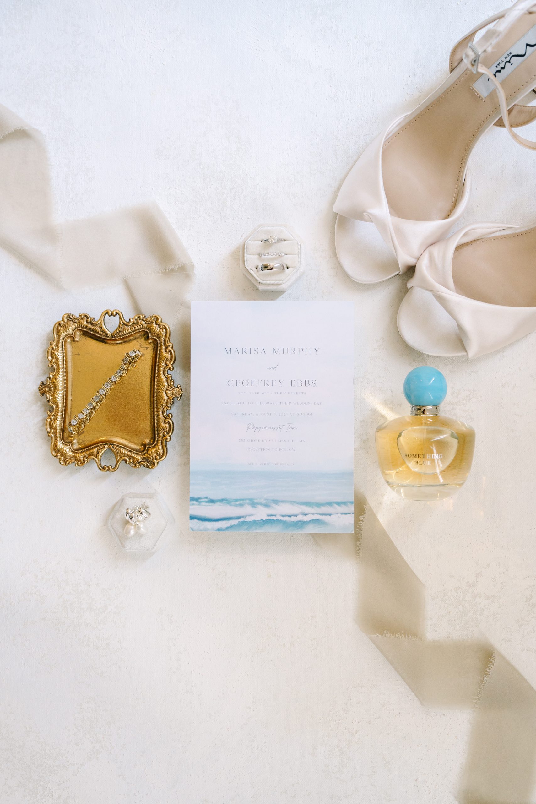 flat lay photo of a bride's detail items on a chasing stone styling mat during her the club at new seabury wedding on cape cod