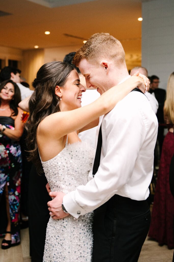 bride in after party dress with arms around the groom dancing during her wychmere beach club dune wedding on cape cod