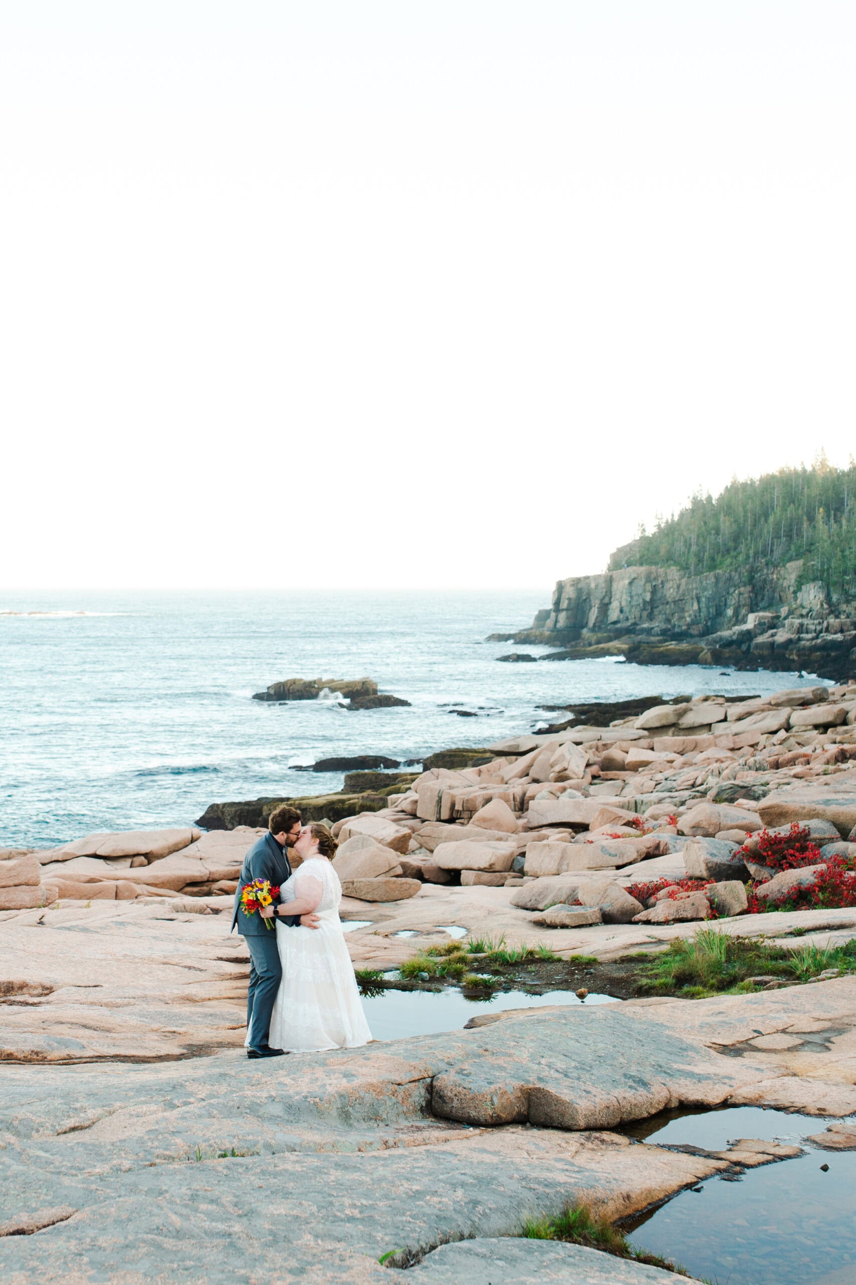 bride and groom kissing during their acadia national park elopement along ocean drive in Maine