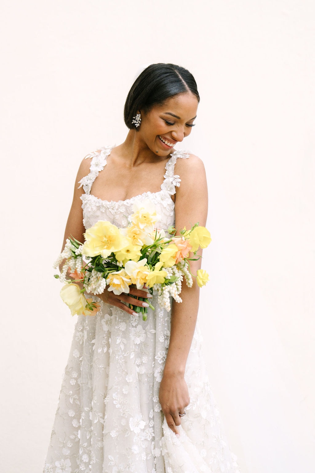 mid length portrait of bride laughing looking down holding her dress and bouquet at a wadsworth mansion wedding