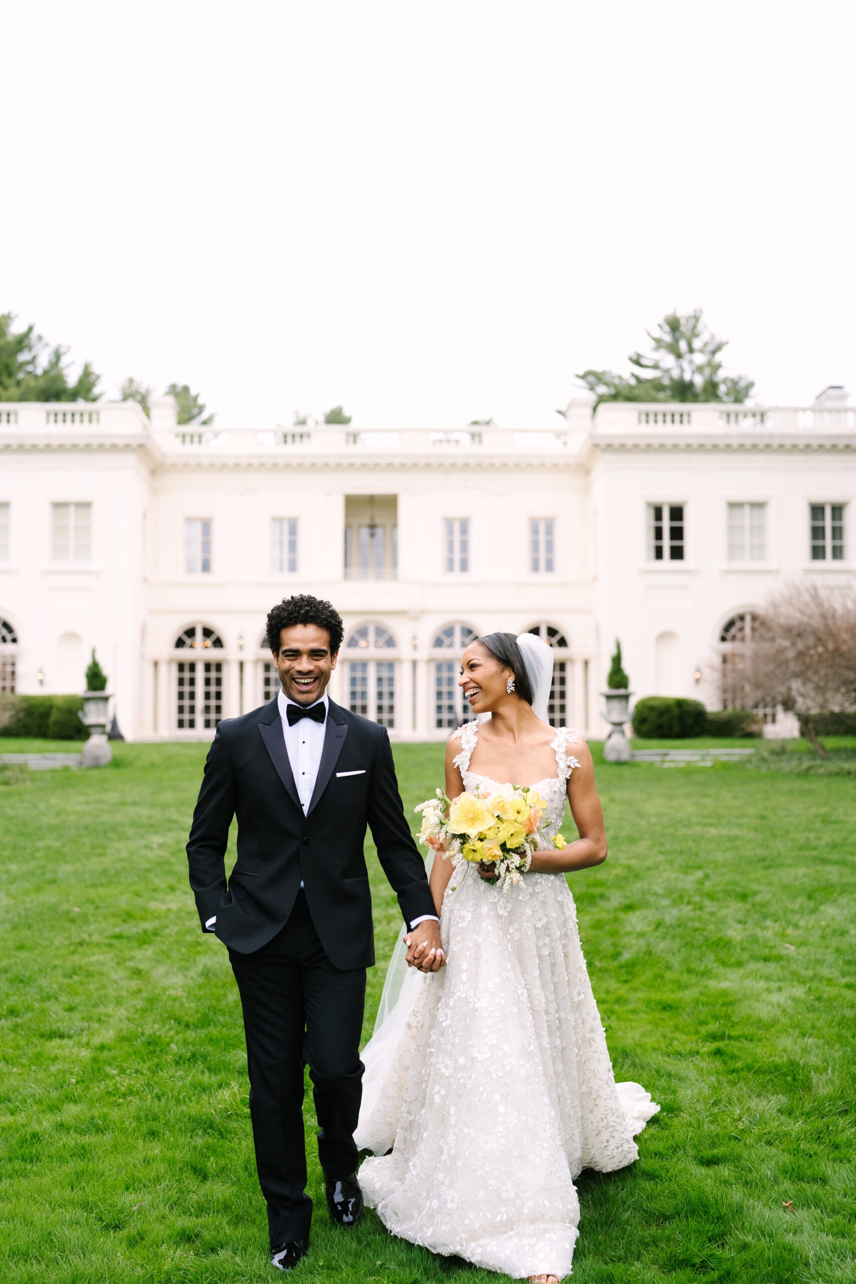 bride and groom laughing walking in front of the wadsworth mansion during their connecticut wedding