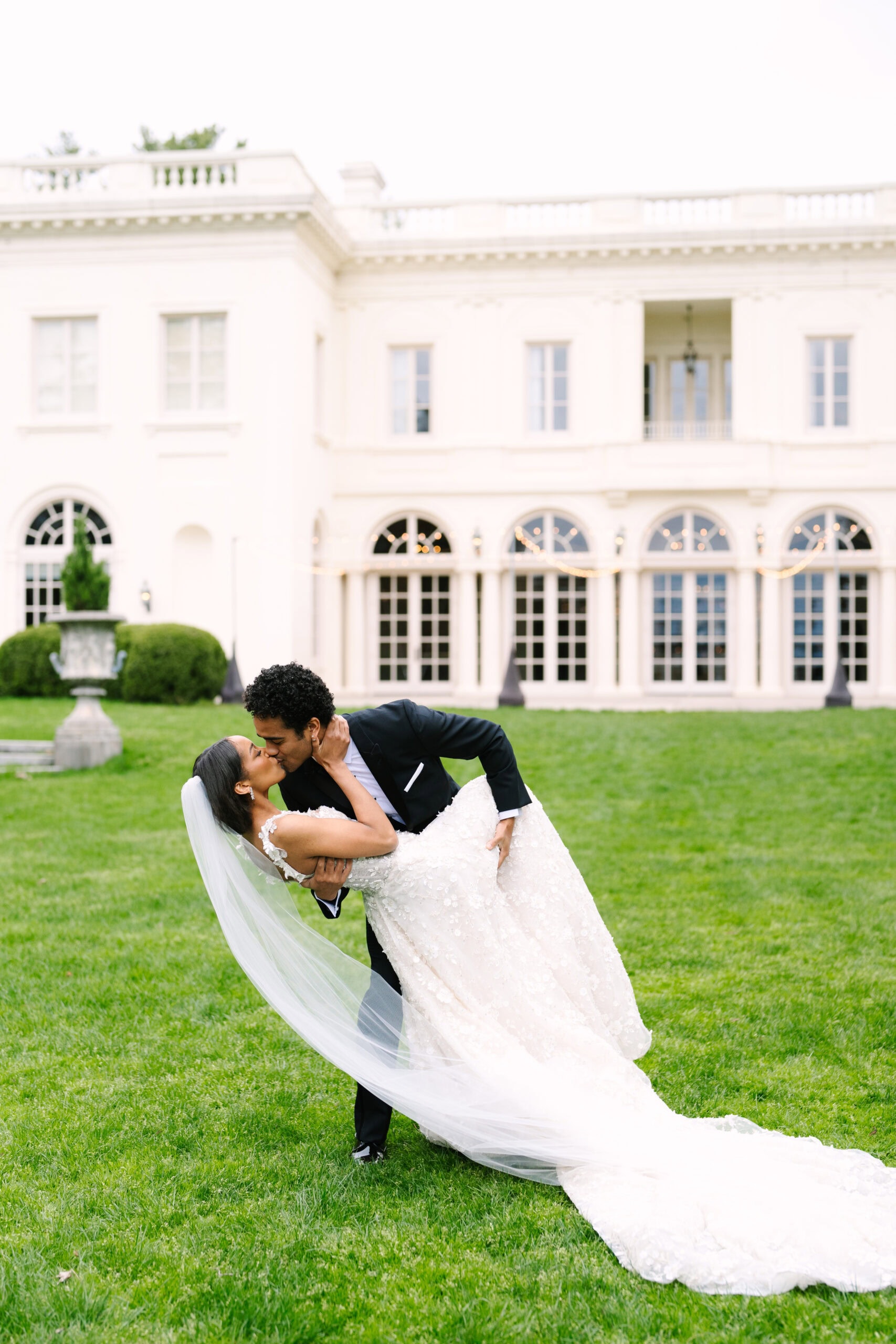 groom dipping bride and giving her a kiss in front of the wadsworth mansion