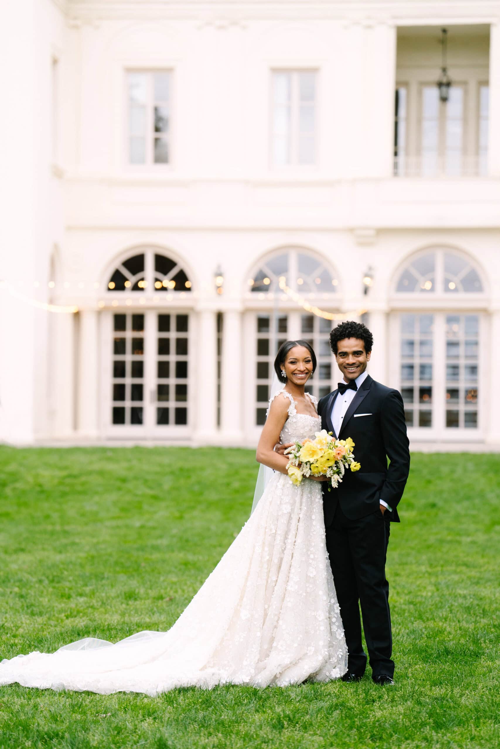 full body vertical portrait of a bride and groom smiling at the camera during their wadsworth mansion wedding