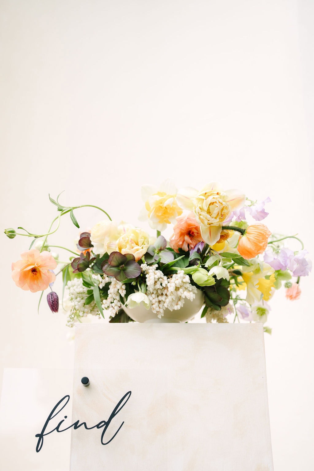 close up on a seating chart pillar with a bouquet on top at the wadsworth mansion at long hill