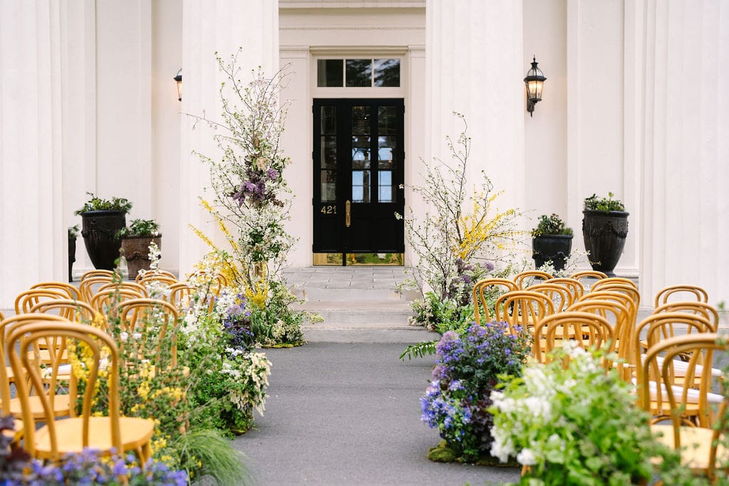 wadsworth mansion ceremony site in front of front pillars adorned with flowers