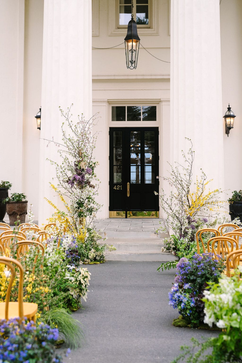 vertical shot of the ceremony aisle adorned with flowers in front of the wadsworth mansion at long hill in connecticut