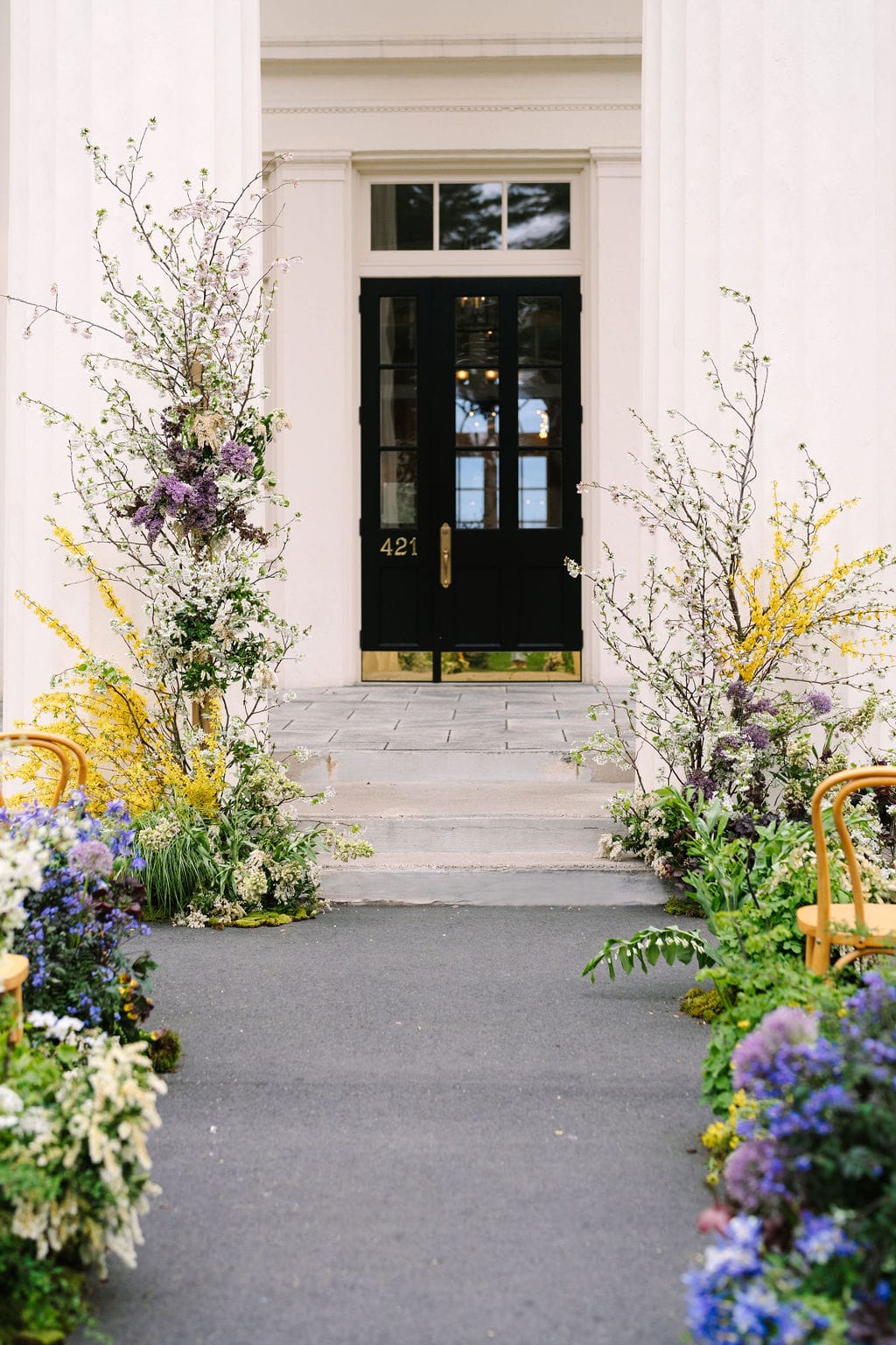 vertical shot of the ceremony aisle adorned with flowers in front of the wadsworth mansion at long hill in connecticut