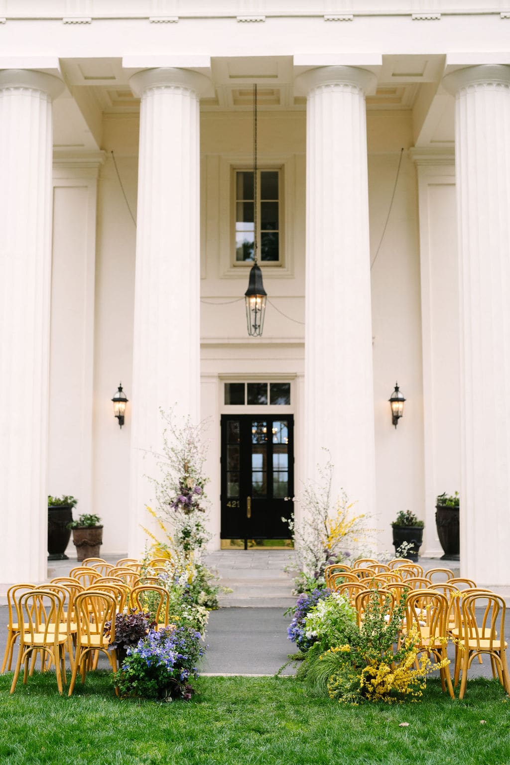 vertical shot of the ceremony aisle adorned with flowers in front of the wadsworth mansion at long hill in connecticut