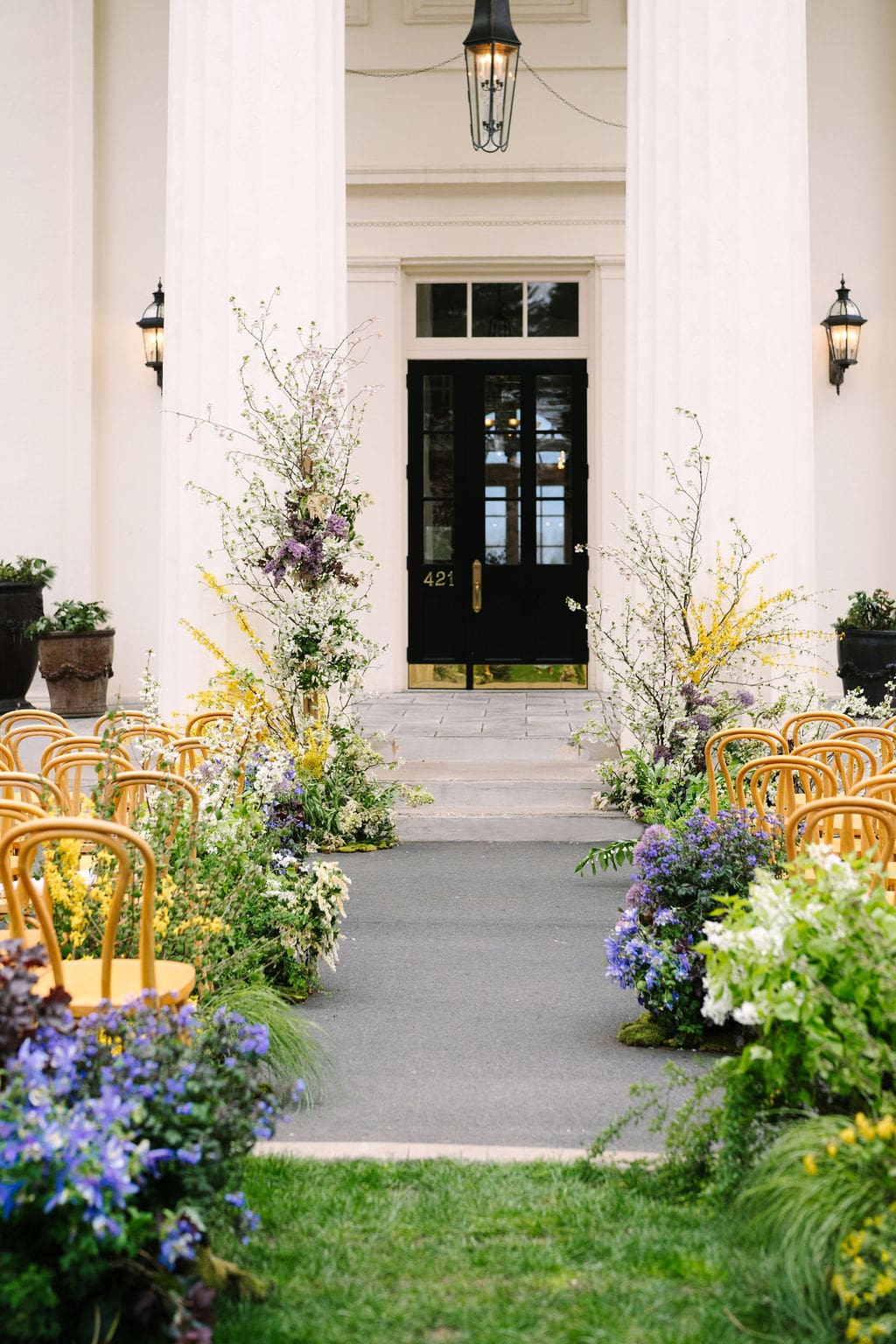 vertical shot of the ceremony aisle adorned with flowers in front of the wadsworth mansion at long hill in connecticut