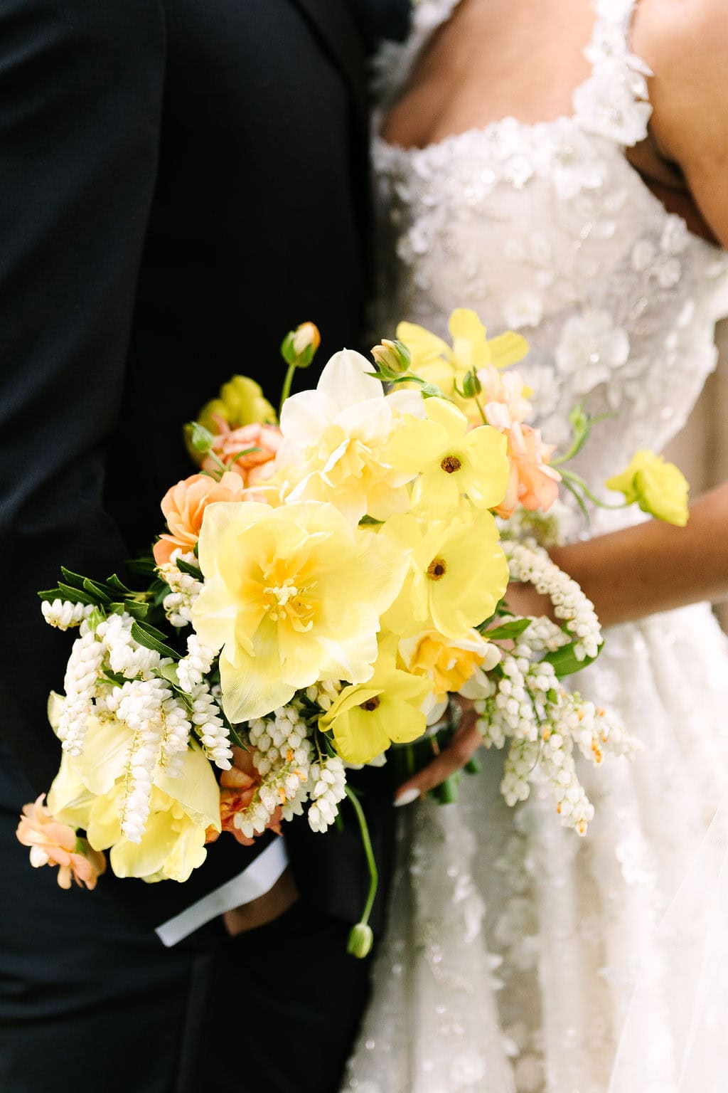 close up of bridal bouquet in between her dress and the groom's suit at a connecticut wedding