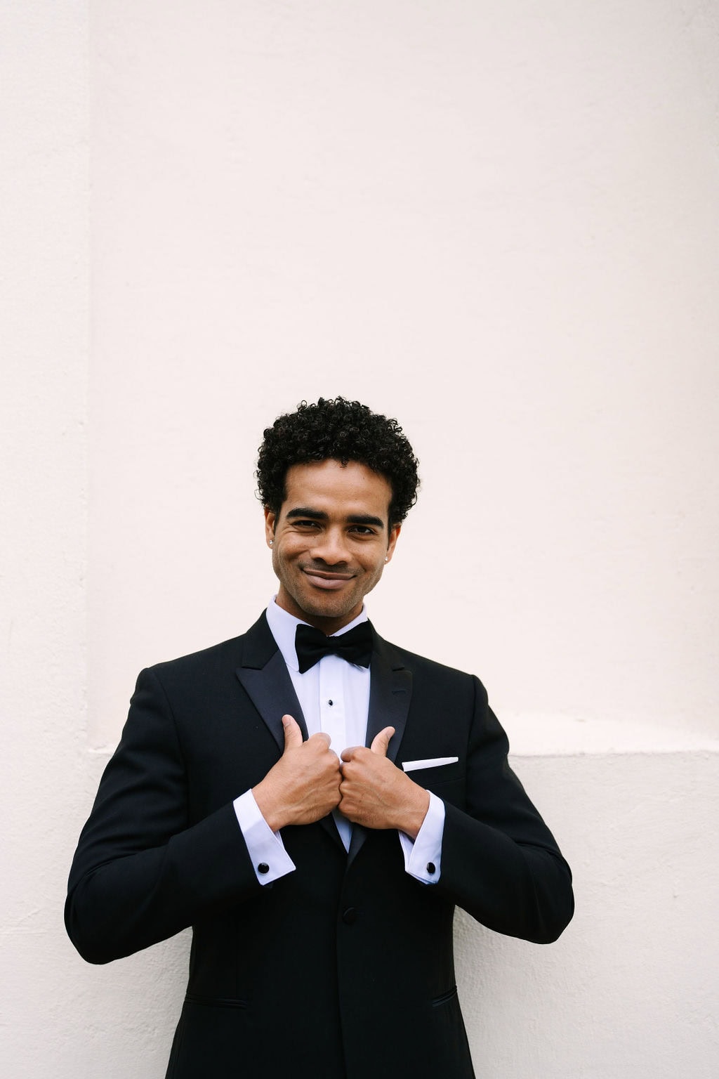 close up portrait of a groom holding the inside of his suit during a black tie wedding at the wadsworth mansion