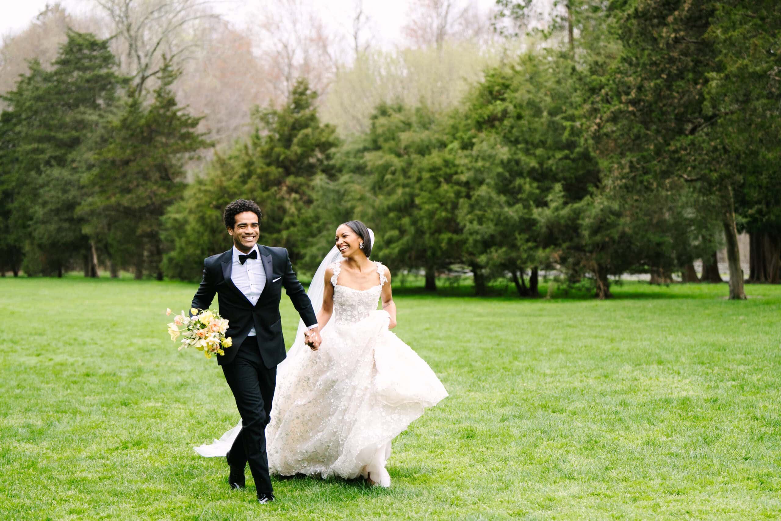 bride and groom smiling running on the lawn of the wadsworth mansion during their connecticut wedding