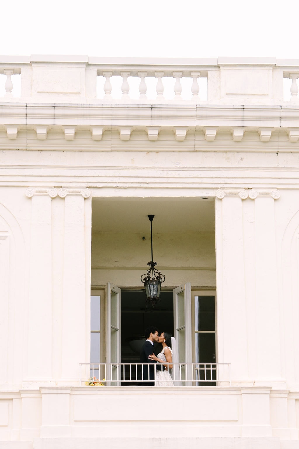 bride and groom kissing on the second floor balcony of the wadsworth mansion during their connecticut wedding